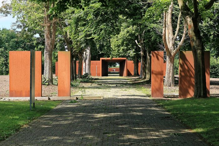 Blick in die Gedenkstätte Esterwegen und die Baumallee mit den rostigbraunen Metall-Stelen, die auf ein Tor hinführen.